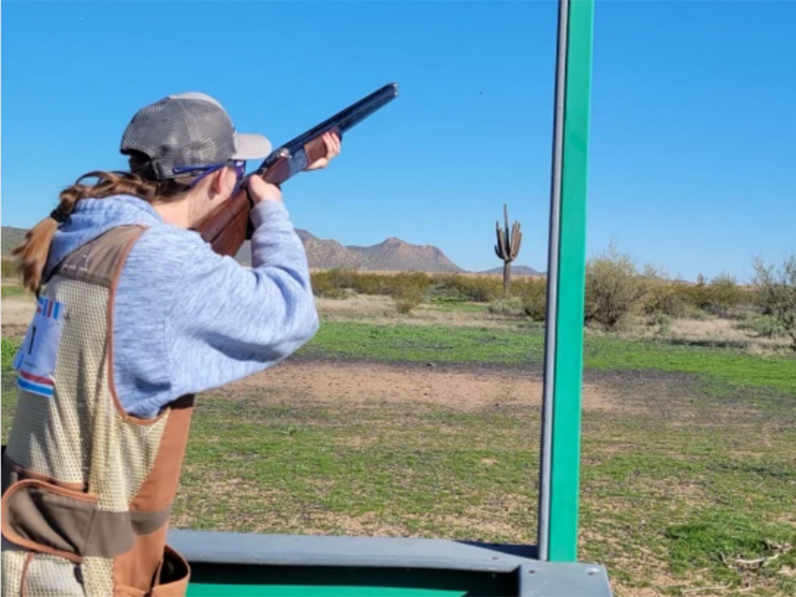 A clay pigeon shooter takes aim on a shooting course